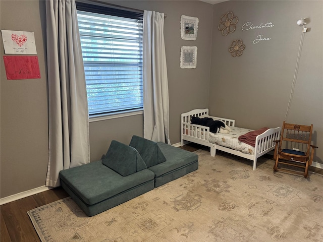 bedroom with baseboards and wood finished floors