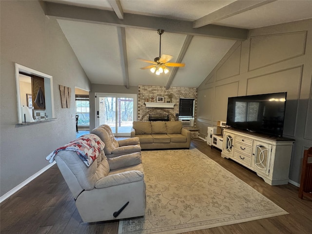 living area featuring baseboards, ceiling fan, lofted ceiling with beams, a fireplace, and dark wood-style floors