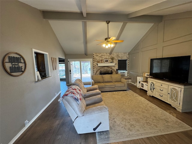 living area with beam ceiling, dark wood-style floors, baseboards, a brick fireplace, and ceiling fan