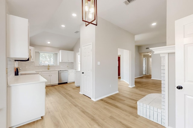 kitchen featuring white cabinetry, stove, light countertops, dishwasher, and tasteful backsplash