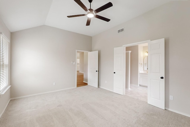 unfurnished bedroom with visible vents, carpet flooring, baseboards, and vaulted ceiling