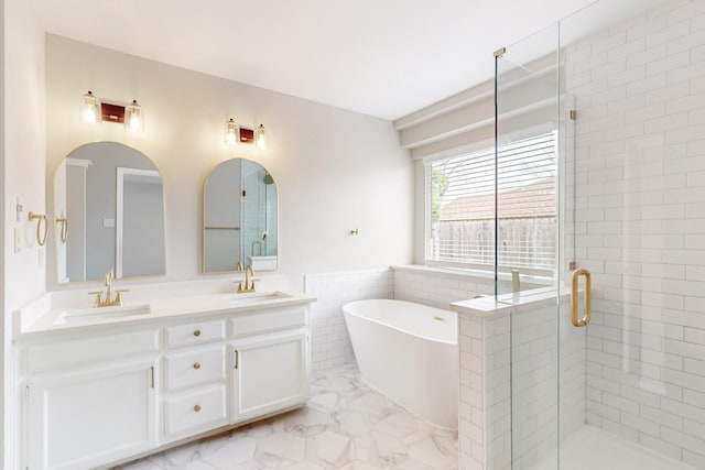 bathroom with a sink, a freestanding bath, marble finish floor, and a stall shower