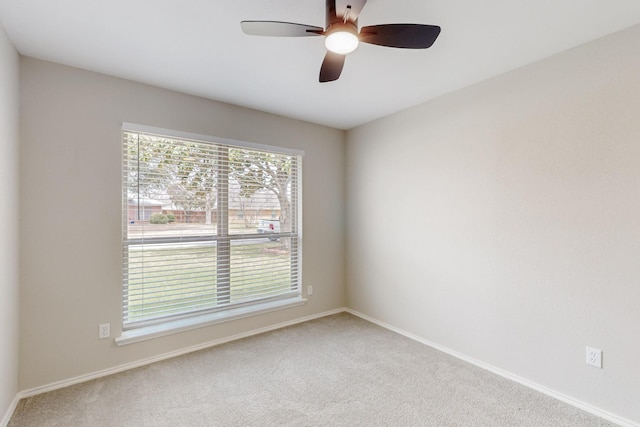 carpeted empty room with baseboards and ceiling fan