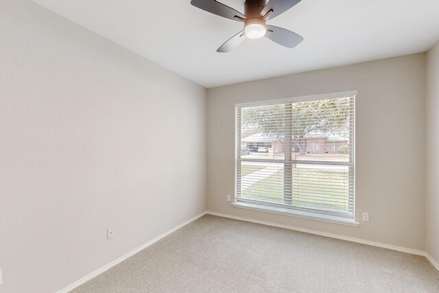 spare room with baseboards, light carpet, a healthy amount of sunlight, and a ceiling fan