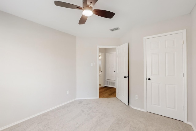 unfurnished bedroom with light carpet, visible vents, ceiling fan, and baseboards