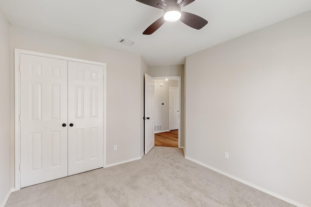 unfurnished bedroom with carpet flooring, baseboards, visible vents, and a closet