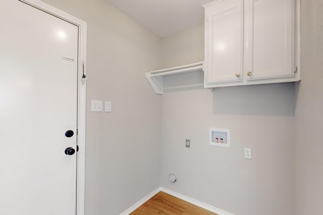 clothes washing area with baseboards, light wood-type flooring, hookup for a washing machine, cabinet space, and hookup for an electric dryer