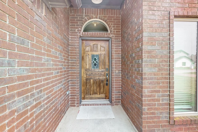 property entrance featuring brick siding