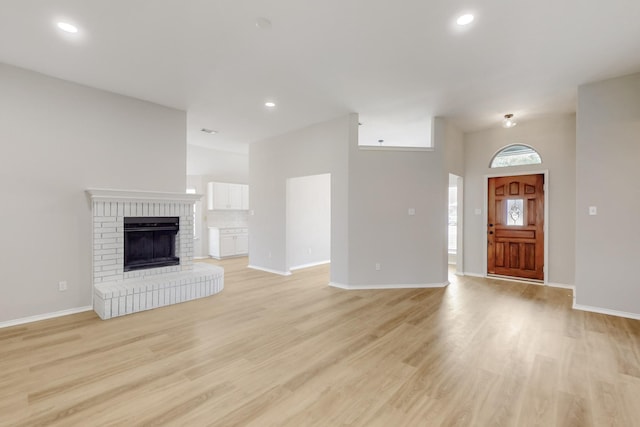 unfurnished living room with recessed lighting, light wood-type flooring, and baseboards