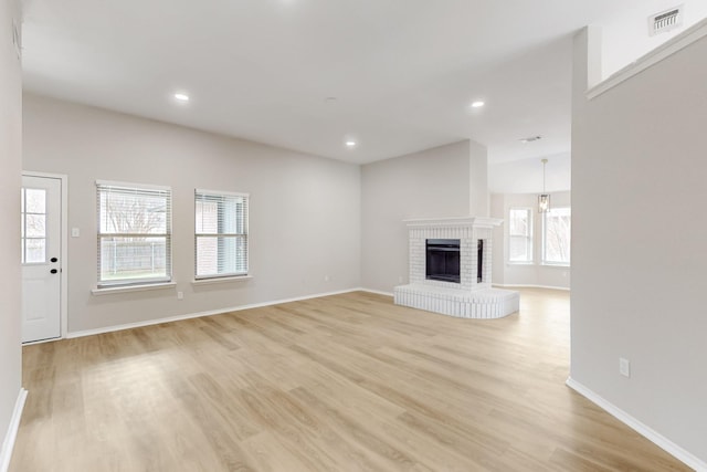 unfurnished living room featuring visible vents, a brick fireplace, baseboards, recessed lighting, and light wood-style flooring