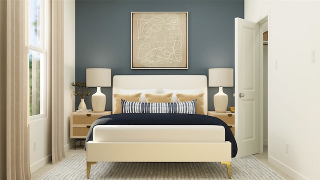 carpeted bedroom featuring multiple windows and baseboards