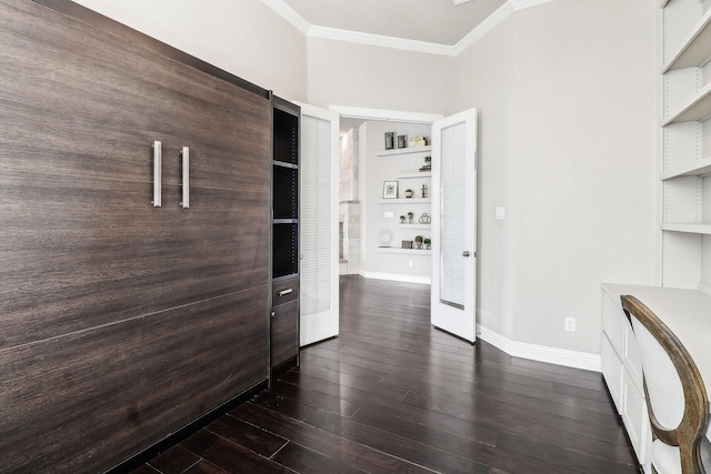 interior space with dark wood finished floors, built in shelves, crown molding, and baseboards