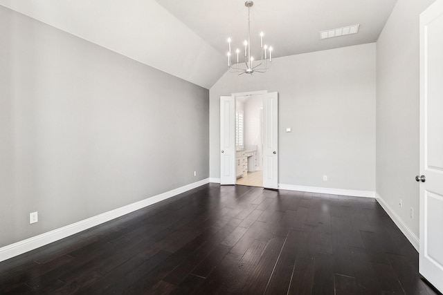 spare room with baseboards, visible vents, dark wood finished floors, vaulted ceiling, and a notable chandelier