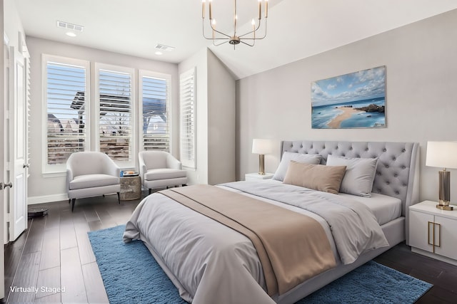 bedroom with a notable chandelier, visible vents, and dark wood finished floors