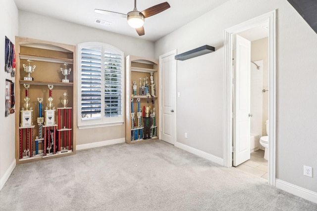 interior space featuring visible vents, baseboards, a ceiling fan, and carpet flooring