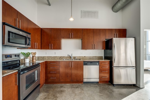 kitchen featuring visible vents, stainless steel appliances, a high ceiling, and a sink