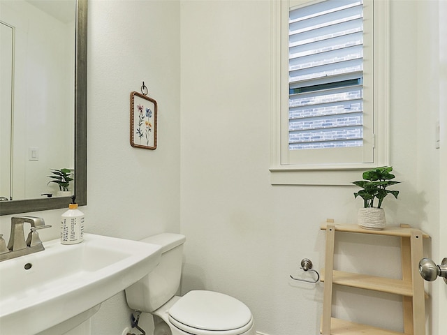 half bathroom with toilet and a sink