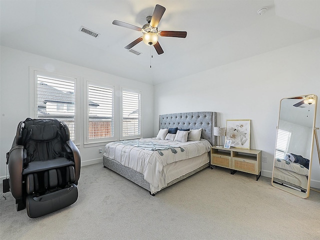 bedroom with baseboards, visible vents, and light carpet