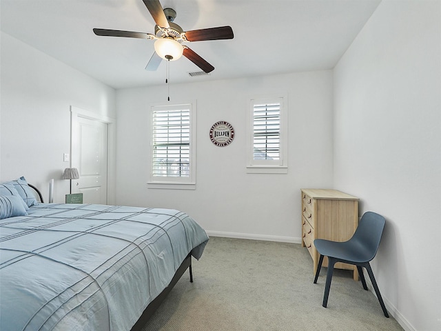 bedroom with ceiling fan, visible vents, baseboards, and light carpet