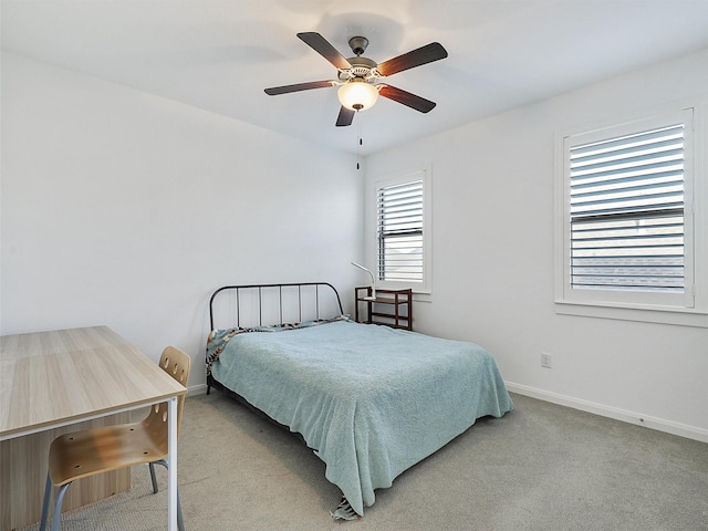 carpeted bedroom with baseboards and a ceiling fan