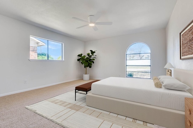 carpeted bedroom with a ceiling fan and baseboards