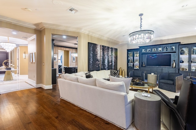 living area with a notable chandelier, crown molding, visible vents, and wood finished floors