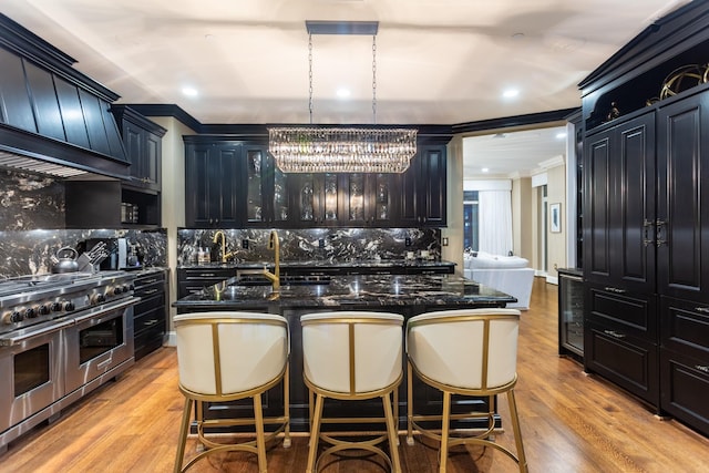 kitchen with a kitchen breakfast bar, light wood-style flooring, double oven range, and a sink