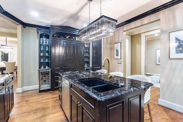 kitchen with beverage cooler, light wood finished floors, a breakfast bar, a sink, and a chandelier