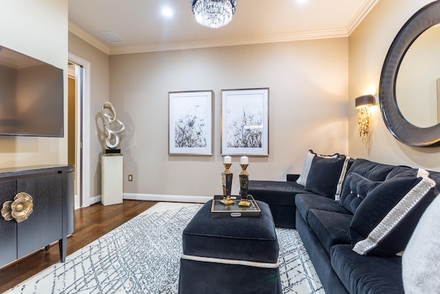 living room with visible vents, wood finished floors, baseboards, and ornamental molding