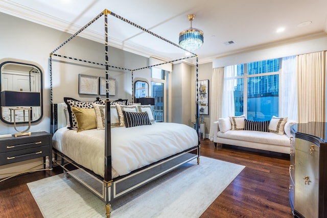 bedroom featuring visible vents, crown molding, and wood finished floors