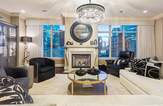 living room with visible vents, crown molding, an inviting chandelier, and a glass covered fireplace