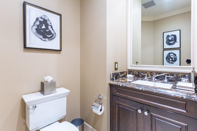 bathroom featuring vanity, crown molding, toilet, and visible vents