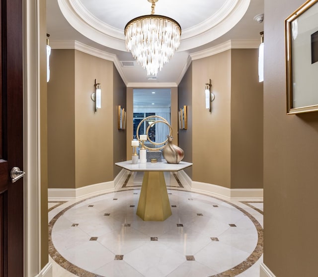 hall featuring visible vents, crown molding, a raised ceiling, and baseboards