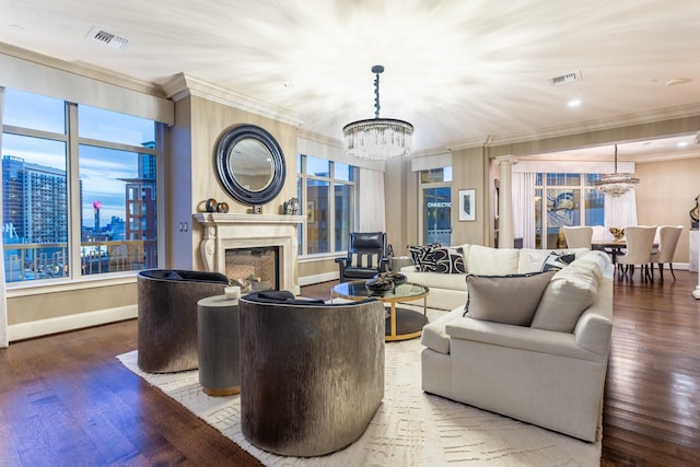 living area featuring visible vents, an inviting chandelier, and ornamental molding