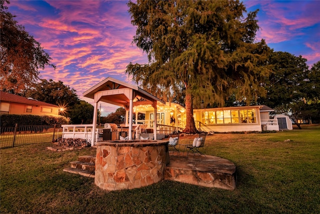 yard at dusk with a patio and fence