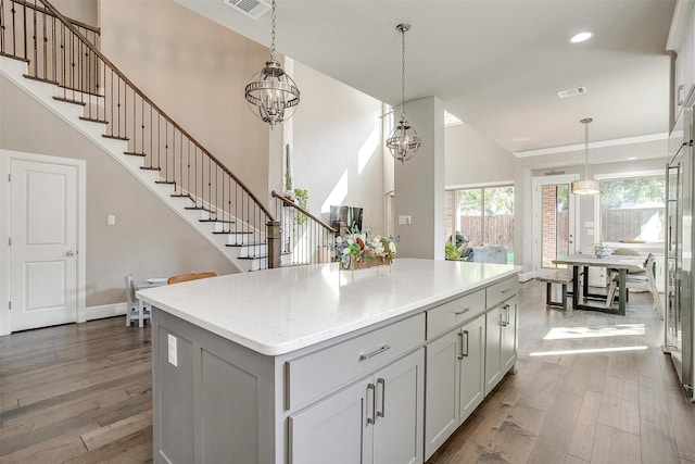 kitchen with visible vents, dark wood-type flooring, pendant lighting, a center island, and recessed lighting