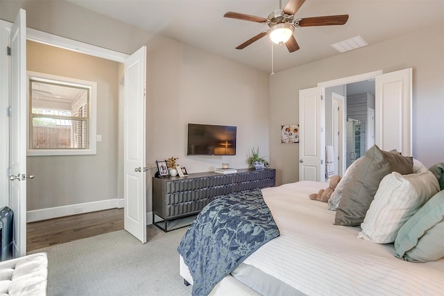 carpeted bedroom featuring baseboards, visible vents, and ceiling fan