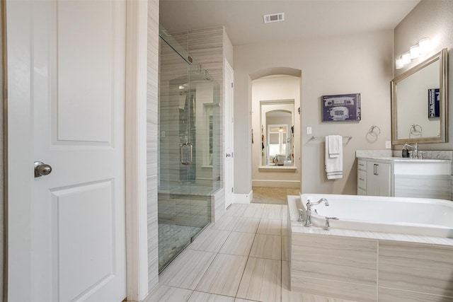 full bath with visible vents, a shower stall, baseboards, a garden tub, and vanity