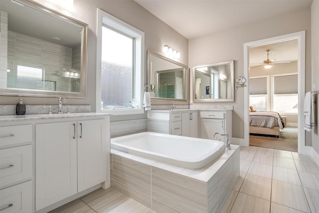 ensuite bathroom with a sink, plenty of natural light, a garden tub, and ceiling fan