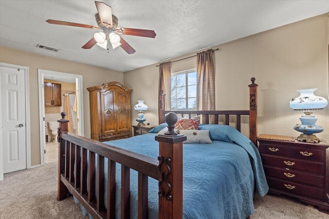 bedroom featuring visible vents, light carpet, a ceiling fan, a textured ceiling, and ensuite bath