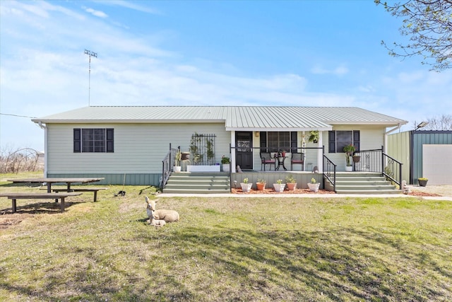 view of front of house featuring a porch, metal roof, and a front lawn