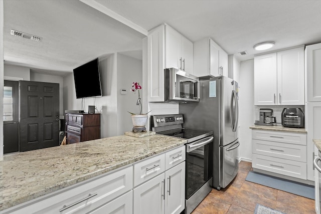 kitchen featuring visible vents, appliances with stainless steel finishes, and white cabinetry