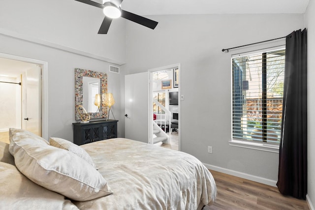 bedroom featuring visible vents, multiple windows, baseboards, and wood finished floors