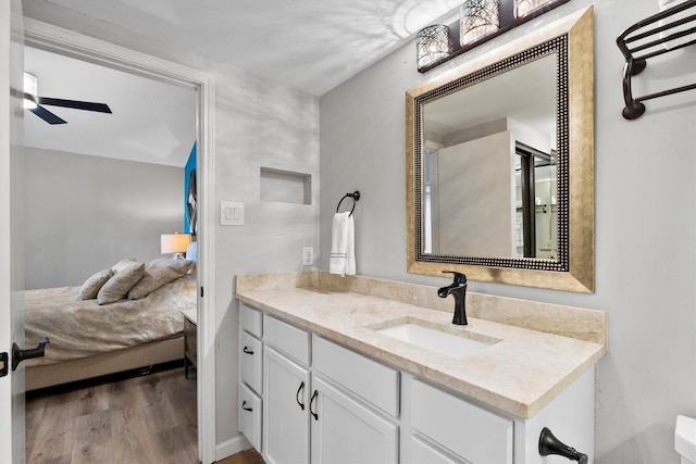 bathroom with ceiling fan, wood finished floors, and vanity