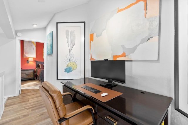 office space with lofted ceiling and light wood-style flooring