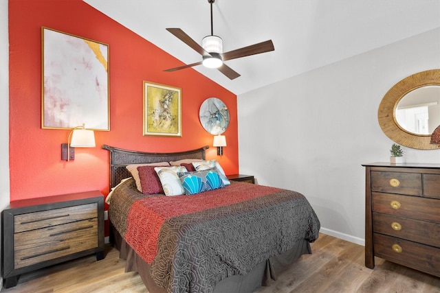 bedroom featuring baseboards, a ceiling fan, lofted ceiling, and wood finished floors