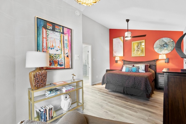 bedroom featuring baseboards, wood finished floors, and vaulted ceiling