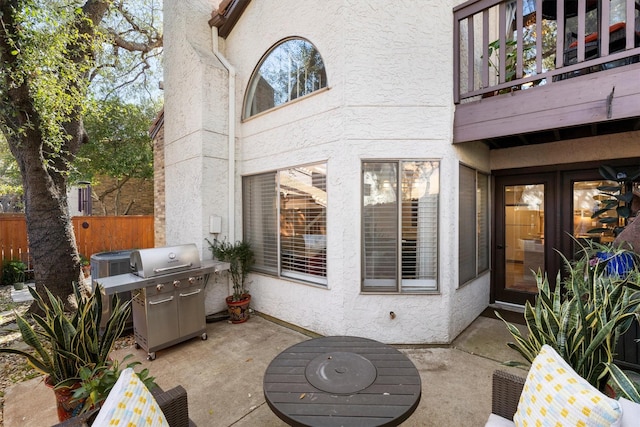 view of patio featuring a balcony, fence, and a grill