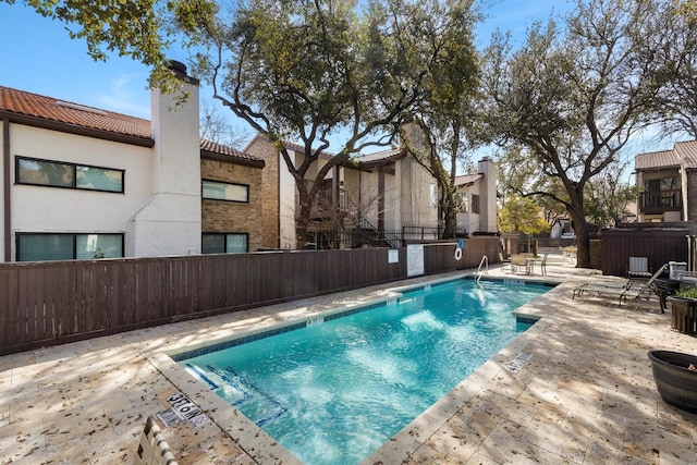 pool with a patio and fence