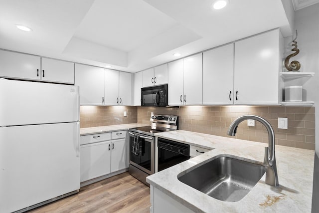 kitchen featuring a sink, a tray ceiling, white cabinets, black appliances, and open shelves